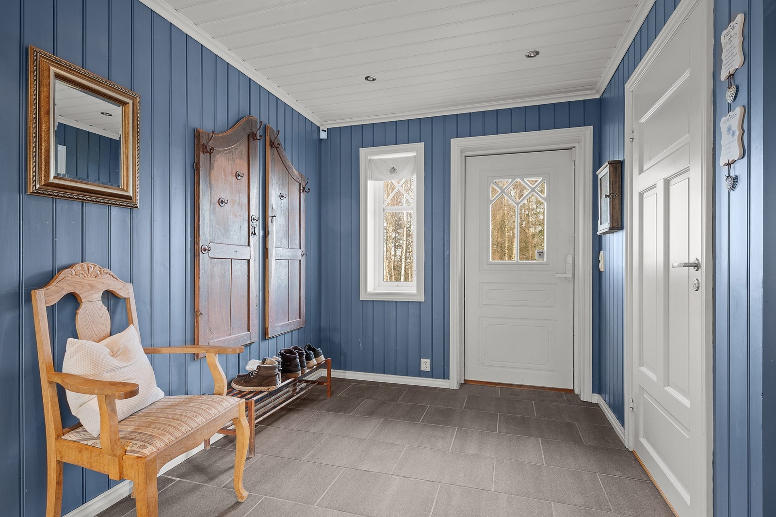 En romslig entré ønsker velkommen. Det er flislagt gulv med vannbåren varme, som er gjennomgående i store deler av etasjen. Galleribilde
