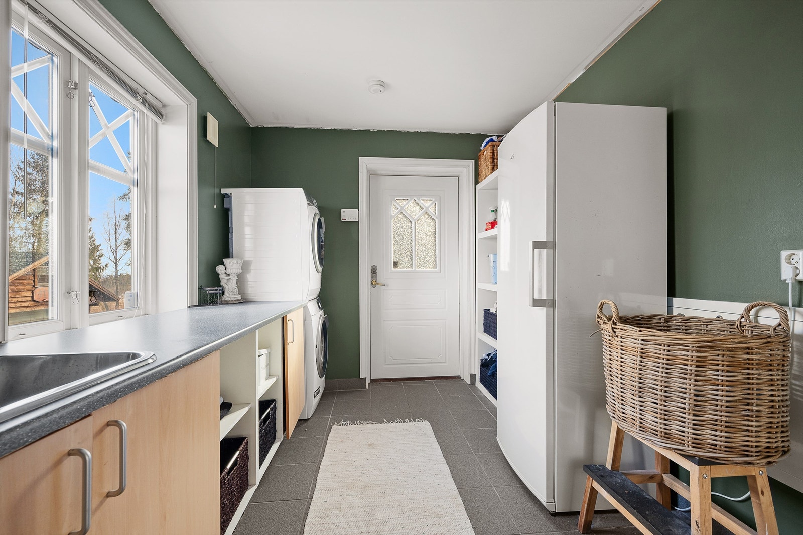 Praktisk vaskerom med egen utgang til hagen, flislagt gulv og vannbåren varme. Galleribilde