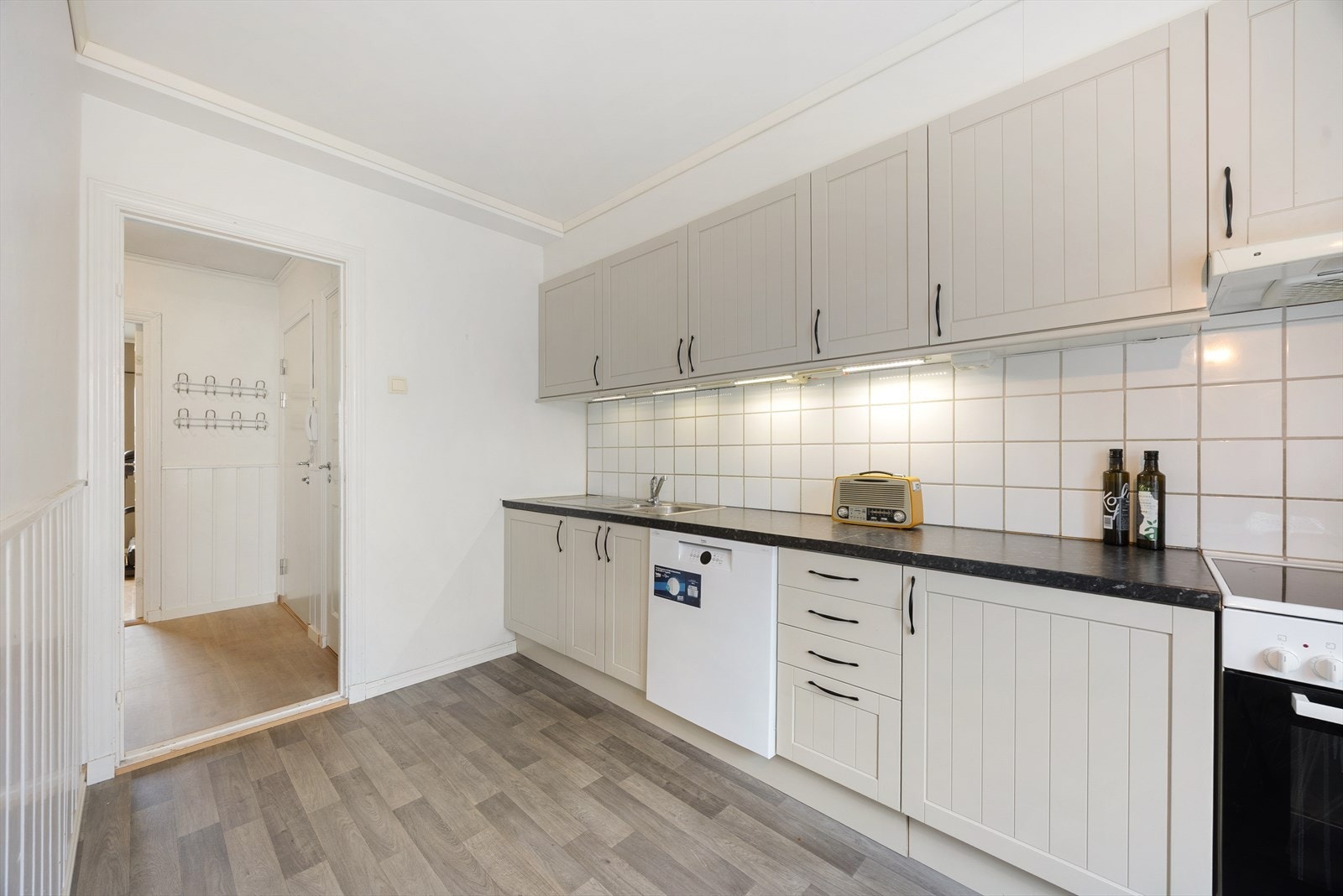 Kjøkken har innredning med profilerte fronterm, flis over benk, lainat benkeplate og belysning. Kjøkkenet er utstyrt med oppvaskkum i rustfritt stål. Galleribilde