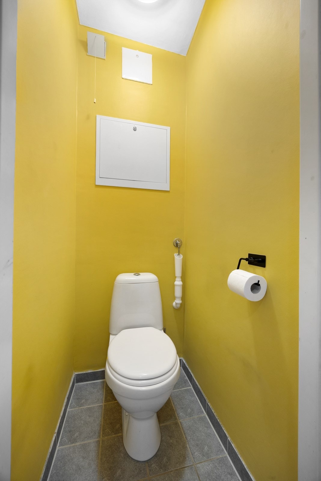 Toalettrom med med flis på gulv, malte flater på vegger og malt tak. Galleribilde