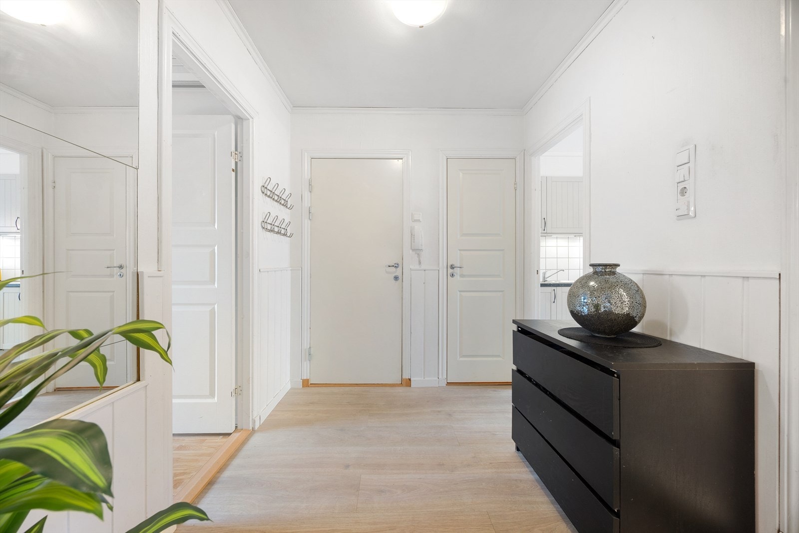 Leiligheten har en romslig entré med lyse veggoverflater. Leiligheten har praktisk porttelefon, som gjør det enkelt å slippe inn besøkende. Galleribilde