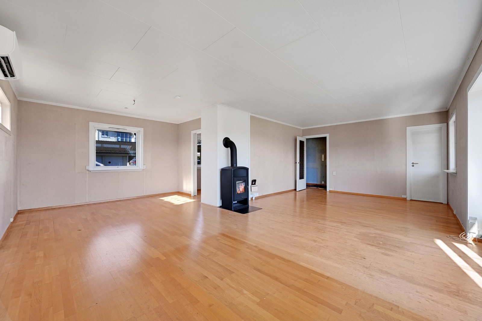 Romslig stue med eikeparkett, varmepumpe og peisovn Galleribilde