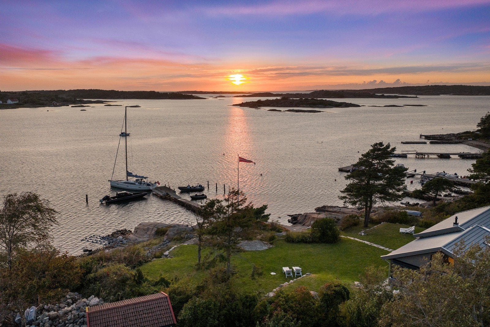 Oversiktsbilde som fremhever bryggeanlegg, strand og gressplen Galleribilde