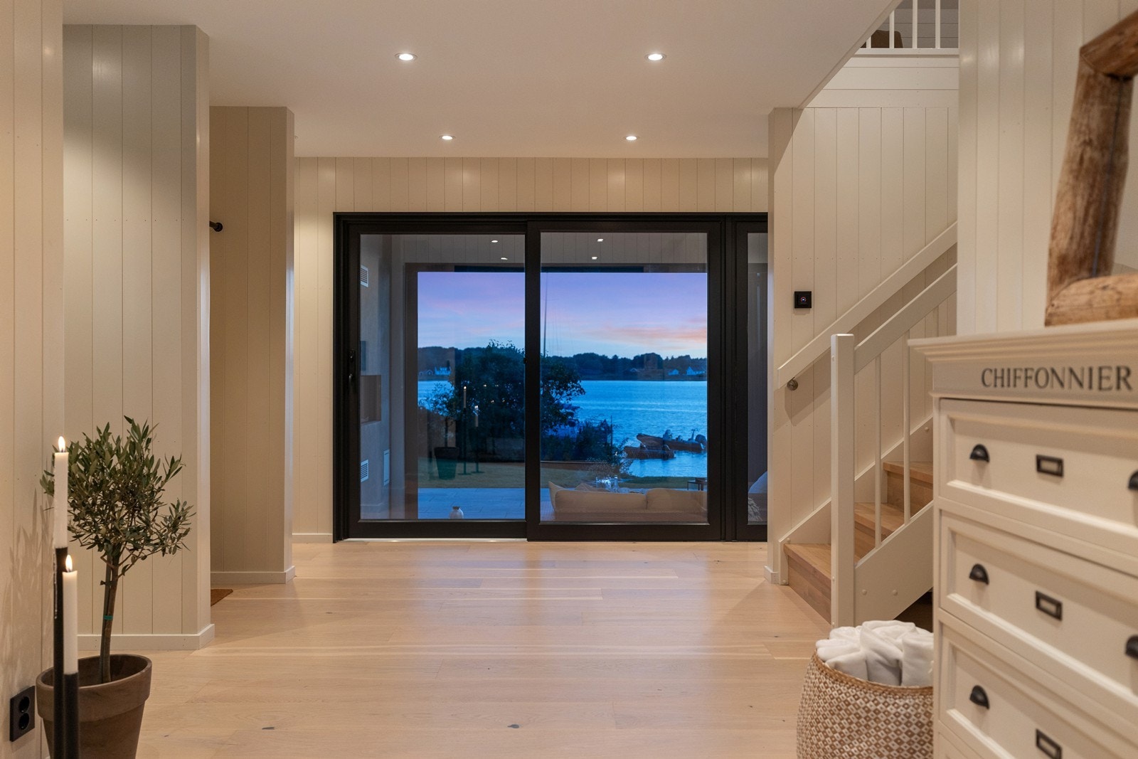 Fra entreen åpner boligen seg mot stuen, der sjøutsikten setter tonen for hele opplevelsen Galleribilde