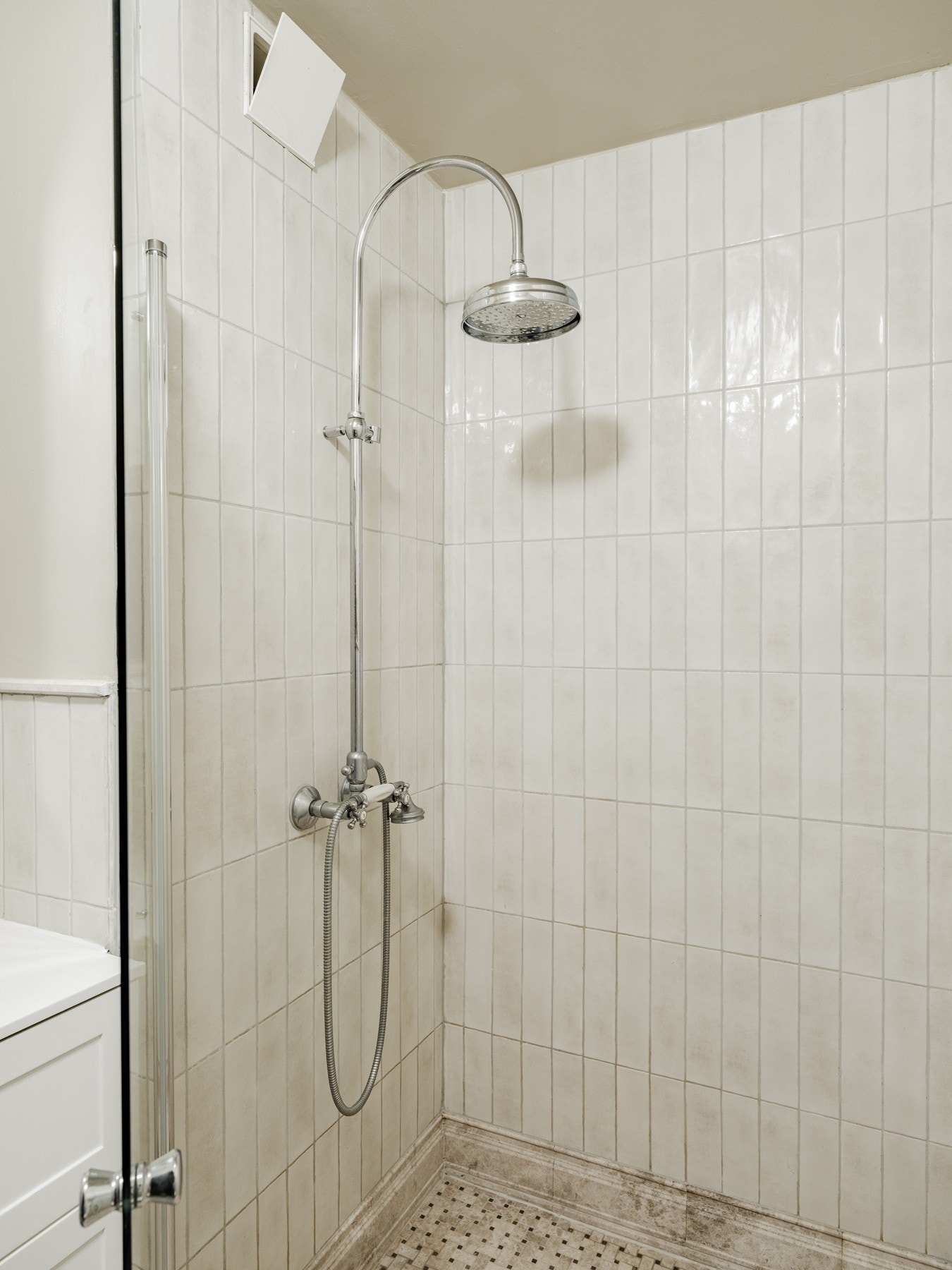 Badet har en elegant dusjnisje med svingbare dusjvegger og termostatstyrt dusjbatteri i krom med hånddusj. Galleribilde