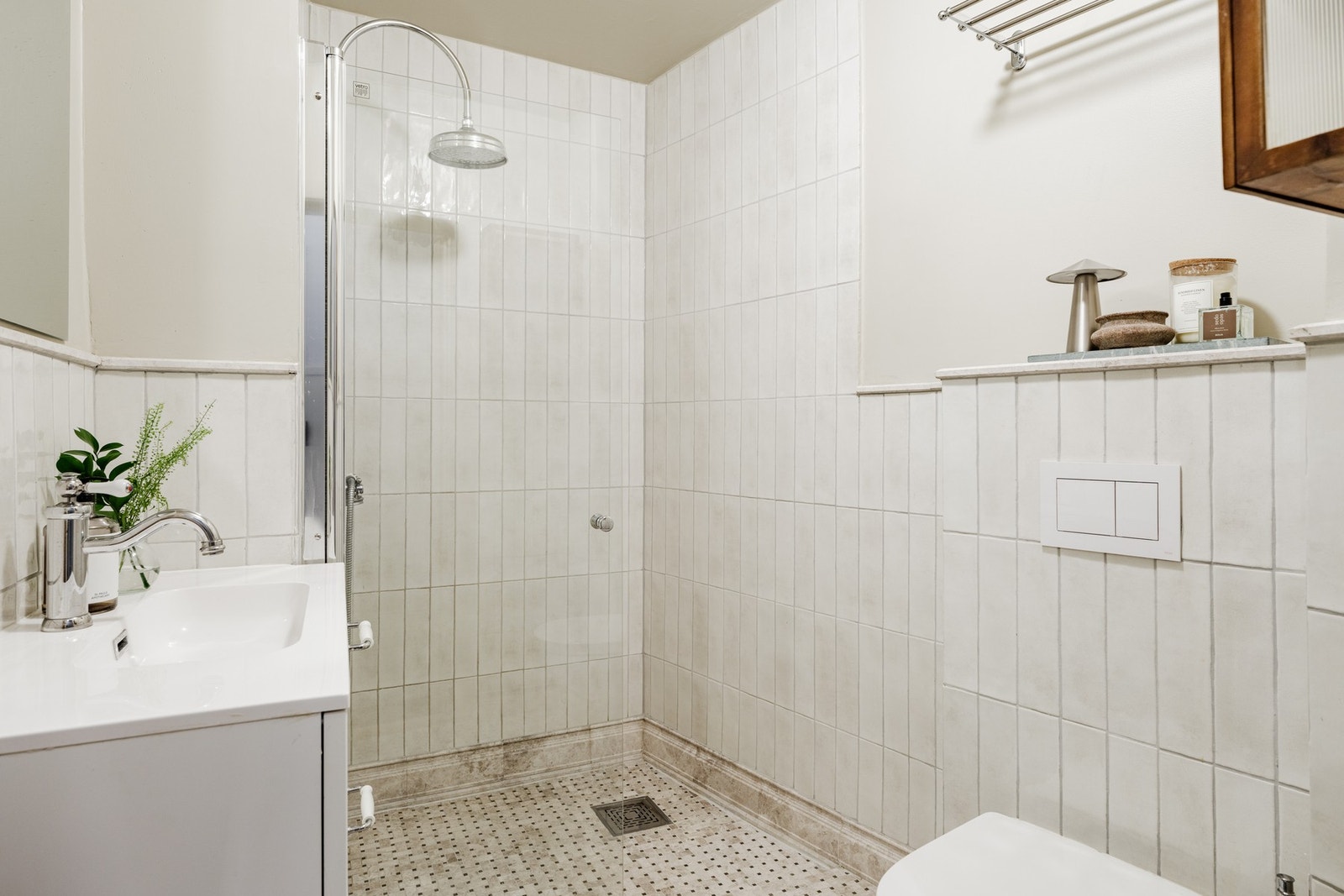 Delikat delvis flislagt bad fra 2024, innredet i klassisk og tidløs stil med varmekabler i gulv som gir ekstra komfort. Galleribilde