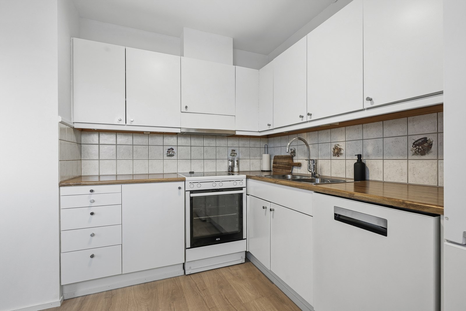 I kjøkkenbenken er det en varmtvannstank på ca. 120 liter fra 2021 og hovedstoppekran. Kjøkkenet er utstyrt med hvitevarer som stekeovn med platetopp, oppvaskmaskin og kjøleskap med frysedel - praktiske løsninger som gjør hverdagen smidig og funksjonell. Galleribilde