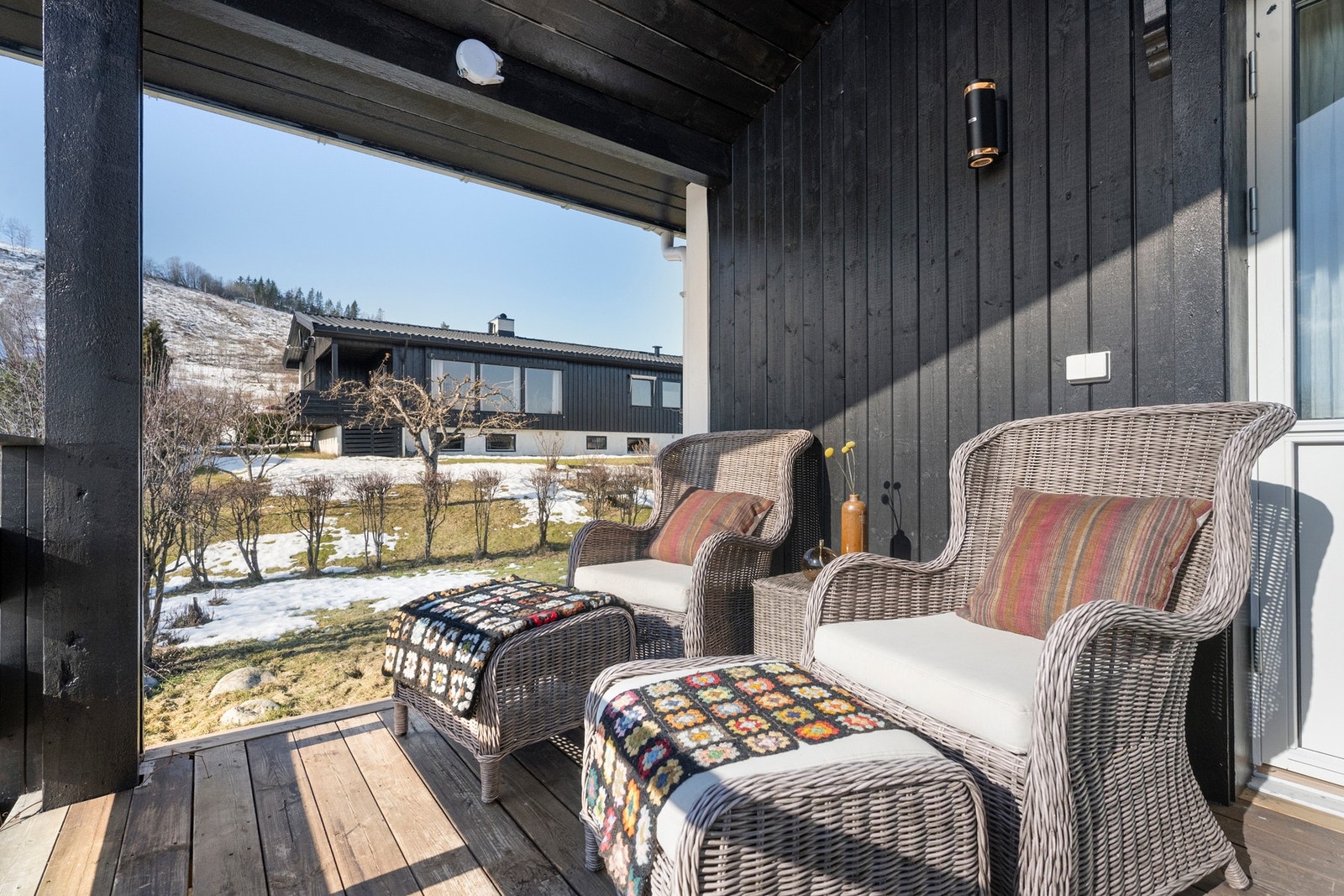 Uteplass med sittegruppe og utsikt mot hage og nærliggende bebyggelse. Galleribilde