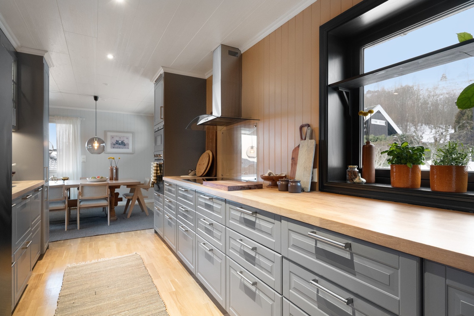 Kjøkken med benkeplate i tre og integrerte hvitevarer. Galleribilde