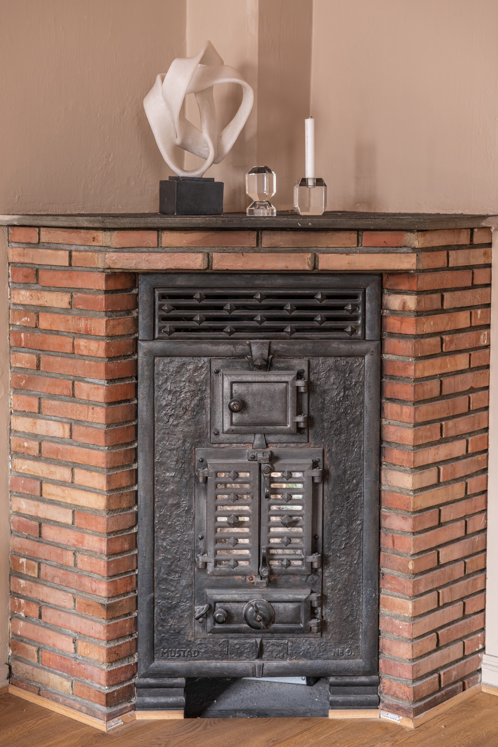 I hjørnet av stuen er det en klassisk vedkamin. Ukjent tilstand på ovn og pipeløp. Originalt pipeløp i bygget som iflg. salg i 2018 har blitt rehabilitert i 2014. Galleribilde