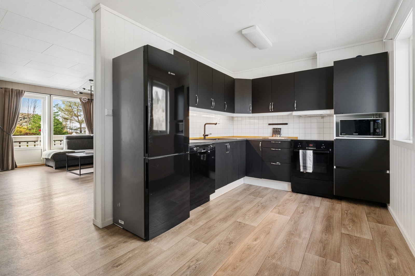 Kjøkkenet er innredet med moderne kjøkkeninnredning, samt benkeplate av laminat med spruteplater over Galleribilde