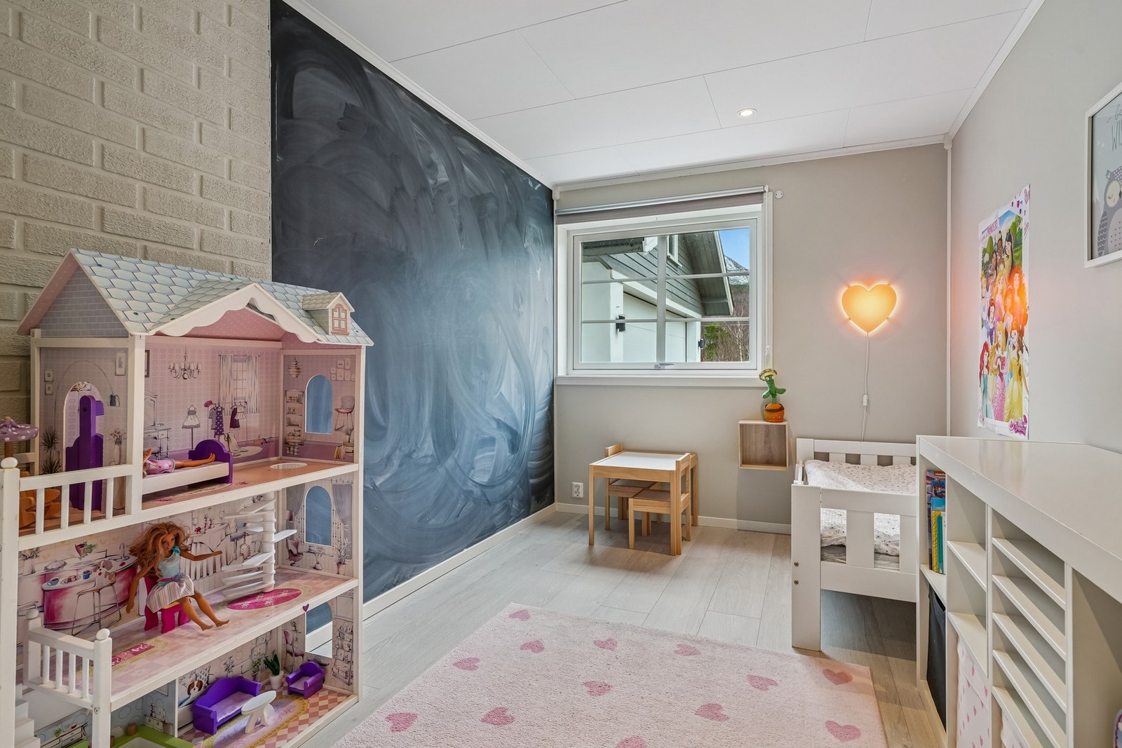 Lyst barnerom med stor tavlevegg og vindu som slipper inn naturlig lys. Galleribilde