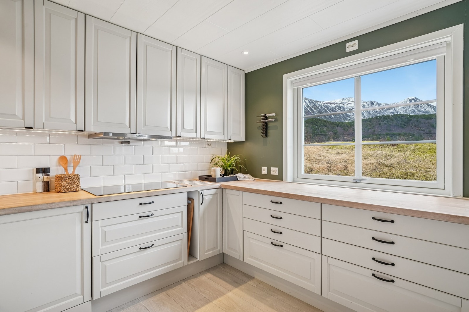 Det er montert fliser på veggene under overskap med belysning. Vinduet gir godt med naturlig lys inn. Galleribilde