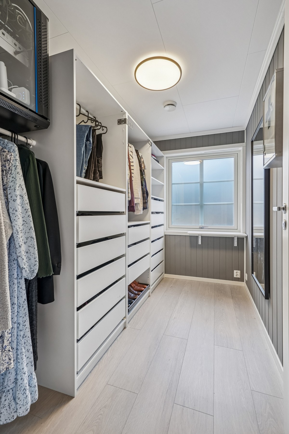 Walk-in garderoberom med rikelig oppbevaringsplass og lysinnslipp fra vindu. Rommet har de samme fine overflatene som de øvrige rom og en praktisk innrending som medfølger. Galleribilde