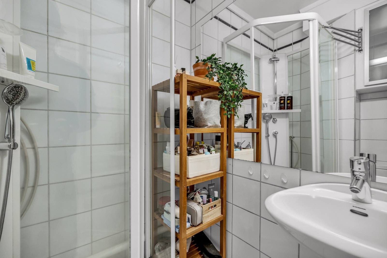 Videre er det gulvstående toalett, dusjkabinett og praktisk vegghengt skap til oppbevaring. Galleribilde