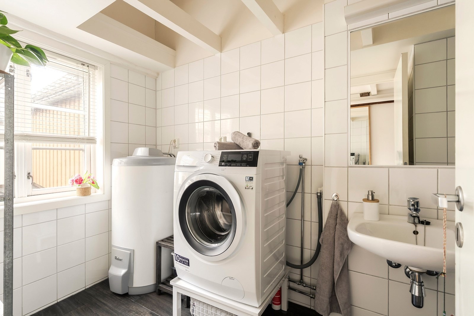 Badet har hvite fliser på veggene og grå fliser på gulv med gulvvarme. Galleribilde