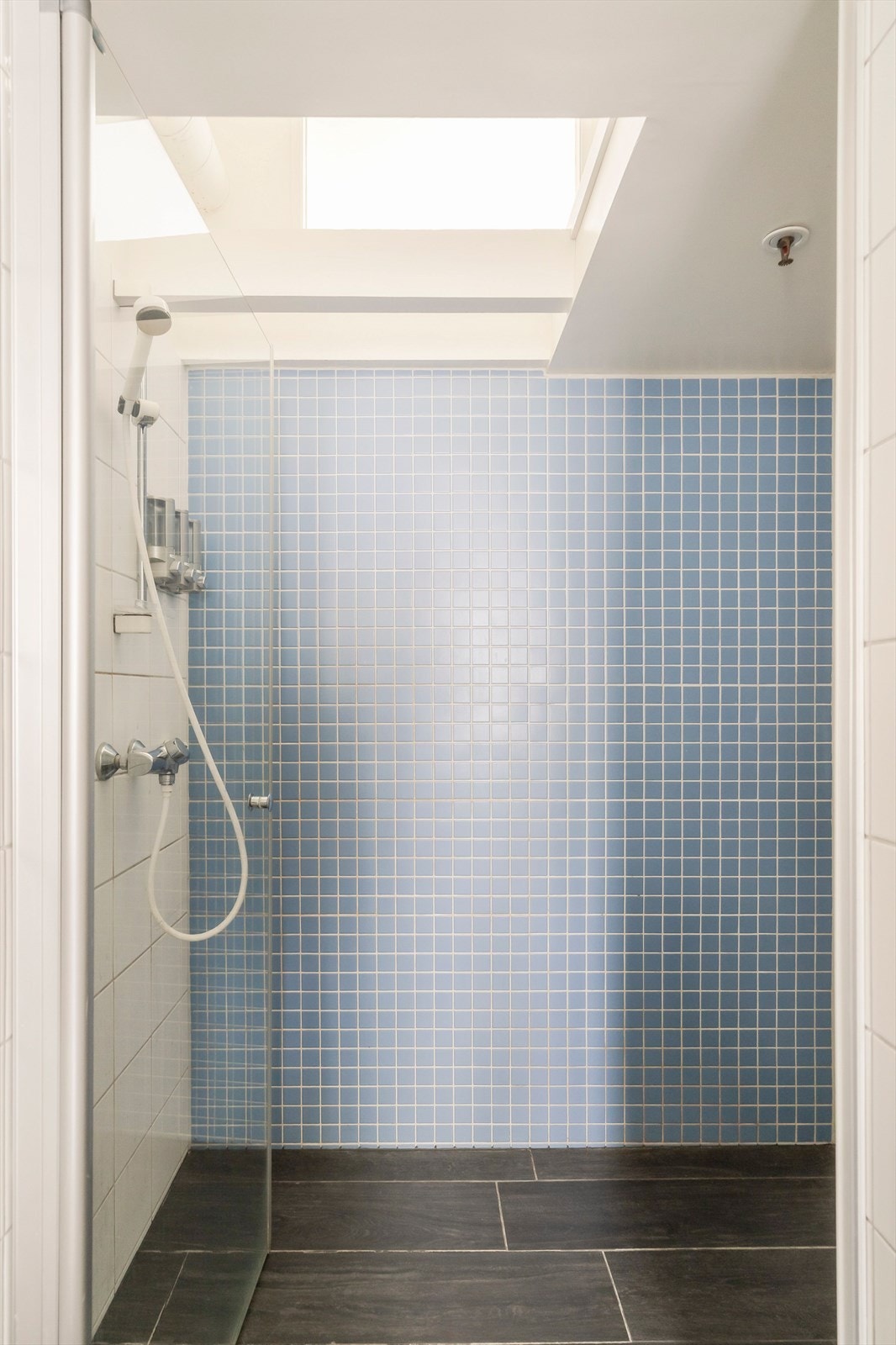 Badet er utstyrt med vegghengt toalett, dusjnisje og opplegg for vaskemaskin. Galleribilde