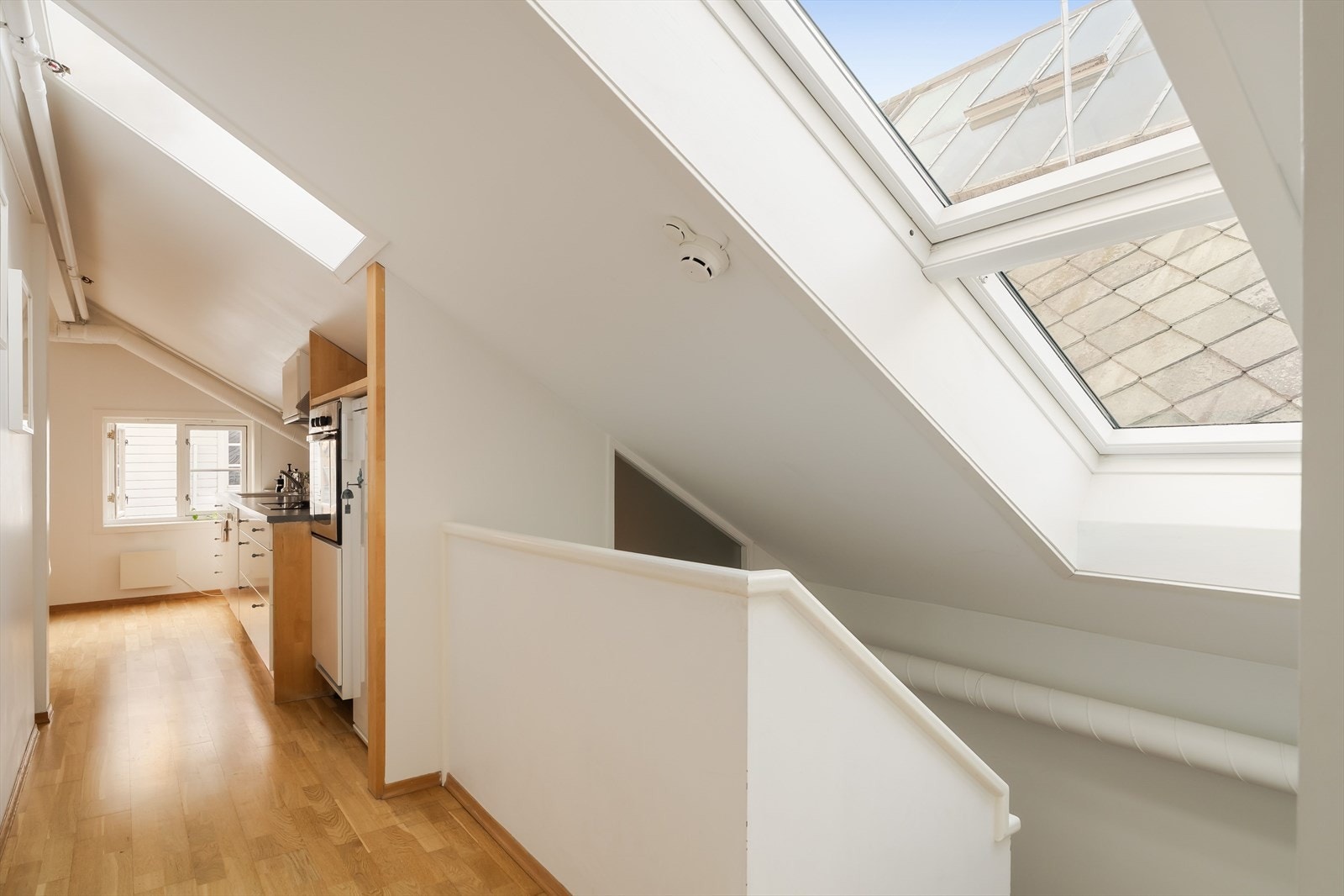 De stilrene, hvite overflatene fremhever det gylne parkettgulvet. Galleribilde