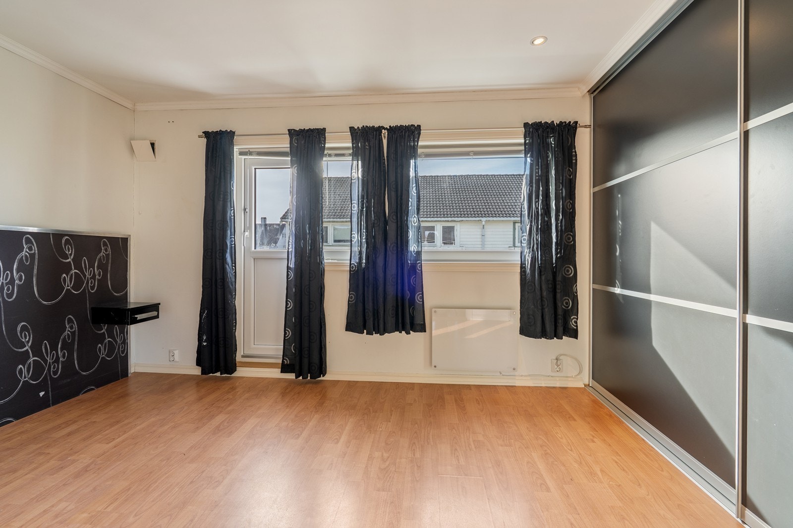 Soverom med laminatgulv, panelovn, plassbygget skyvedørsgarderobe, spotter i tak, persienner i vindu og utgang til luftebalkong mot vest. Galleribilde