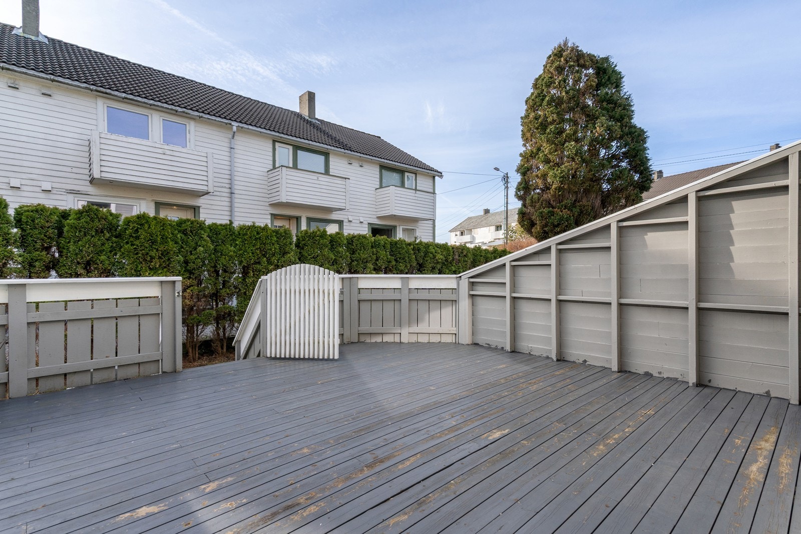 Romslig og solrik terrasse mot vest og port med trapp ned til plen samt skillevegger mot nabo. Galleribilde