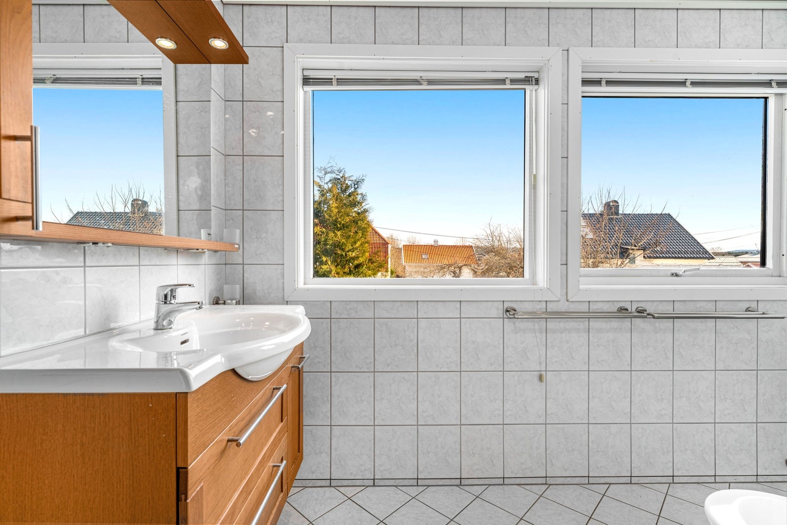 Store vinduer på badet gir godt med dagslys og naturlig ventilasjon. Galleribilde