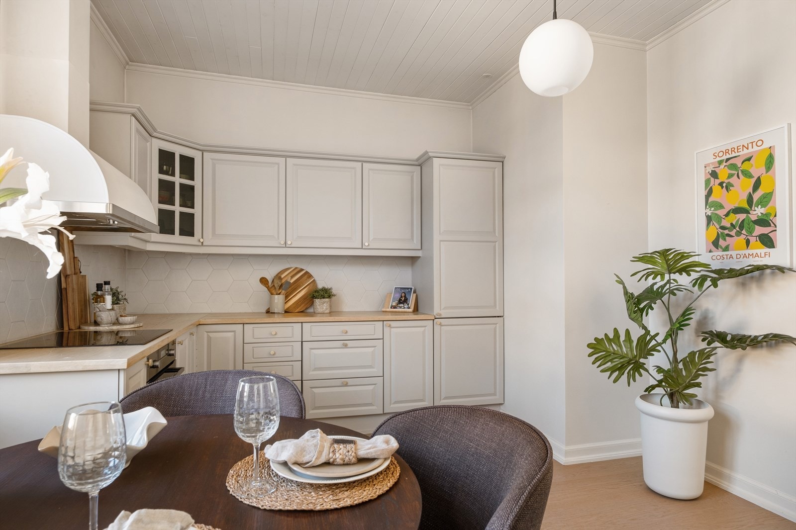 Fliser over benkeplaten gir et stilrent og praktisk uttrykk. Rommet har en hyggelig spiseplass ved vinduet, som slipper inn rikelig med naturlig lys og gir en luftig atmosfære. Galleribilde