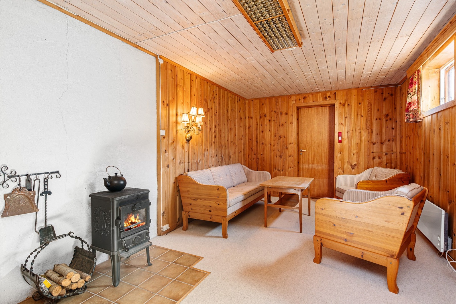 Stor kjellerstue med teppe på gulv og panel på vegger Galleribilde