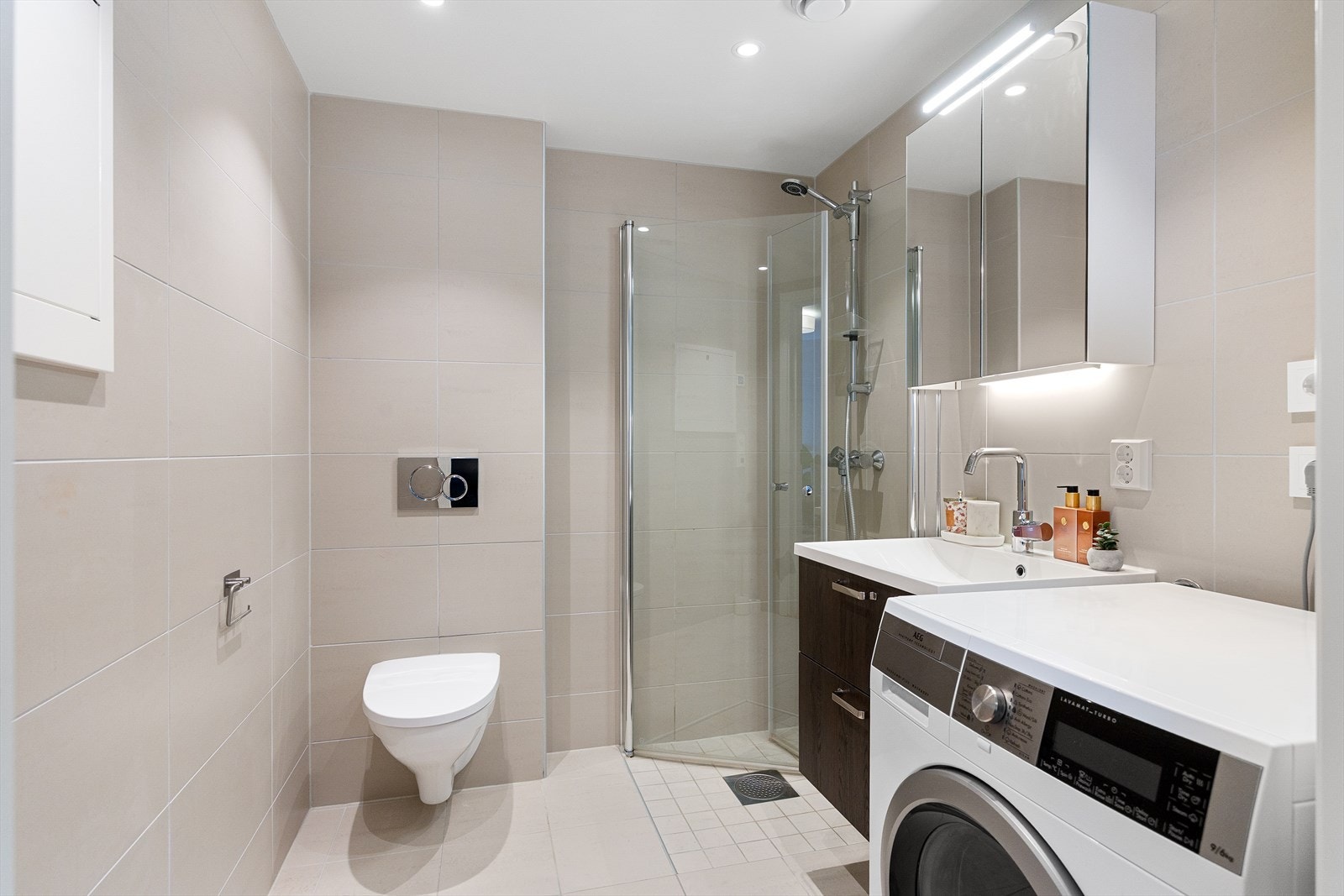 Romslig baderom fra 2023. Badet har tidløse overflater med fliser, elektrisk gulvvarme og downlights i himling. Galleribilde