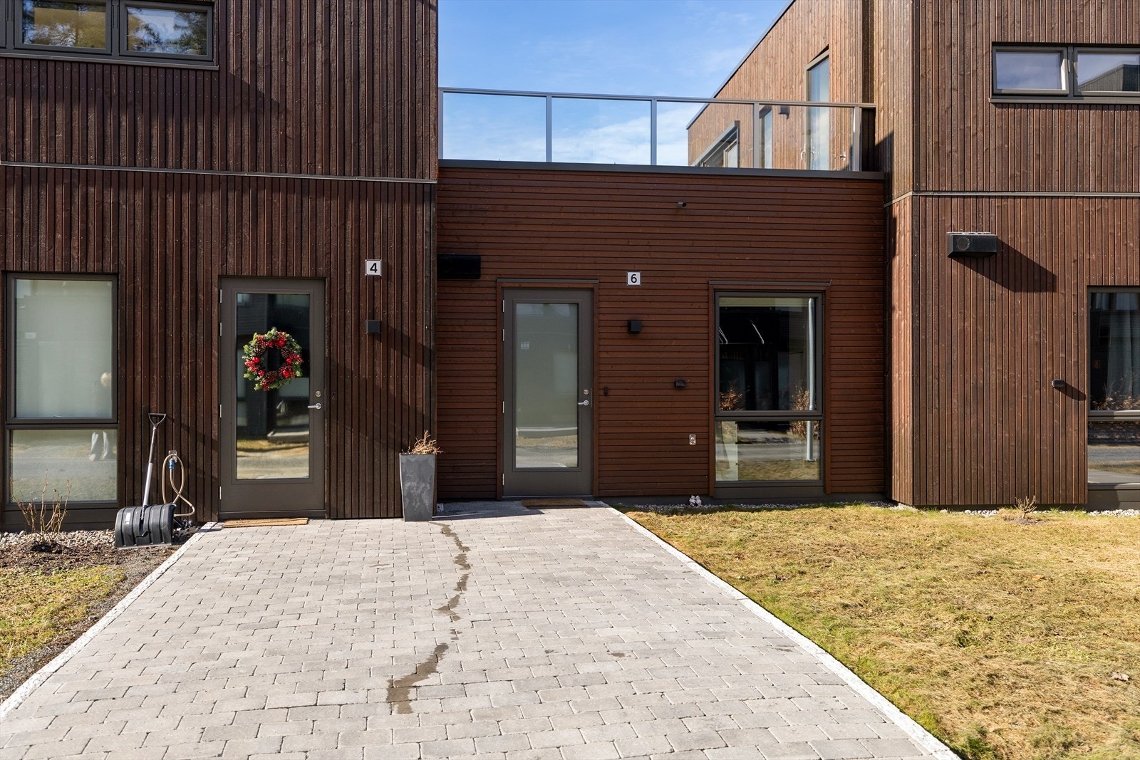 Du ankommer boligen via pent opparbeidet inngangsparti fra sameiets fellesarealer. I 2025 la selger i samarbeid med naboen et brosteinsdekke. Galleribilde