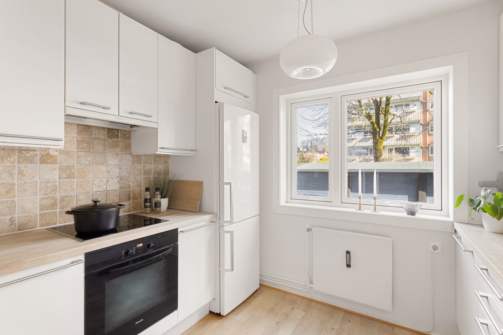 Kjøkkeninnredningen er fra IKEA og har glatte fronter og benkeplate i heltre. Galleribilde