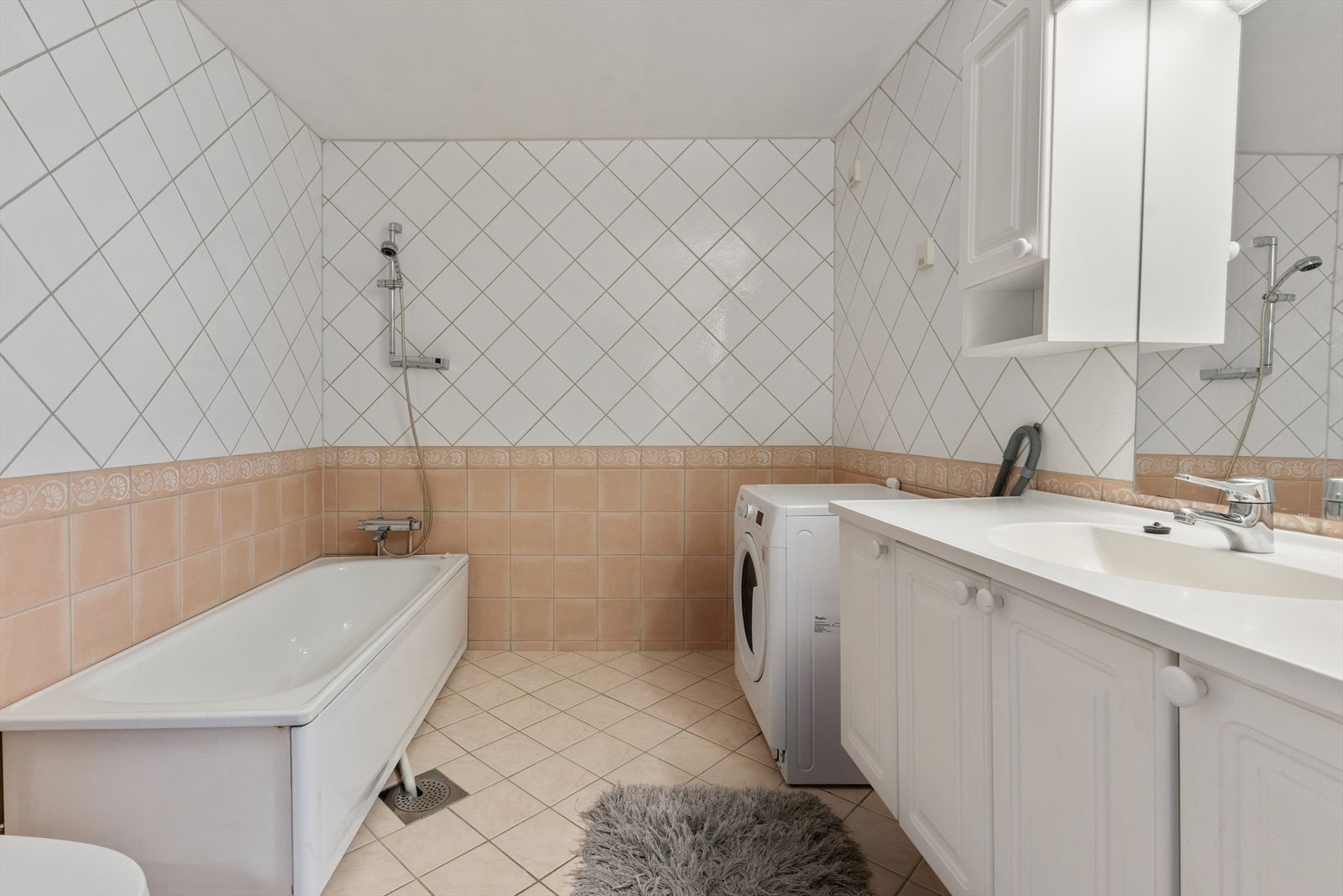 Badet er fra byggeåret og har en funksjonell utforming. Her er det opplegg for vaskemaskin samt plass til nødvendig baderomsinnredning. Galleribilde