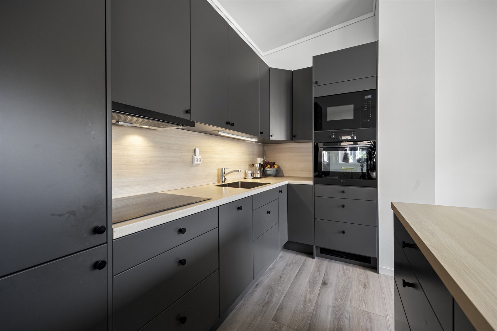 Kjøkken med integrerte hvitevarer som medfølger i handelen. Det er oppvaskmaskin, mikro, stekeovn, koketopp og kjøl/frys. Galleribilde