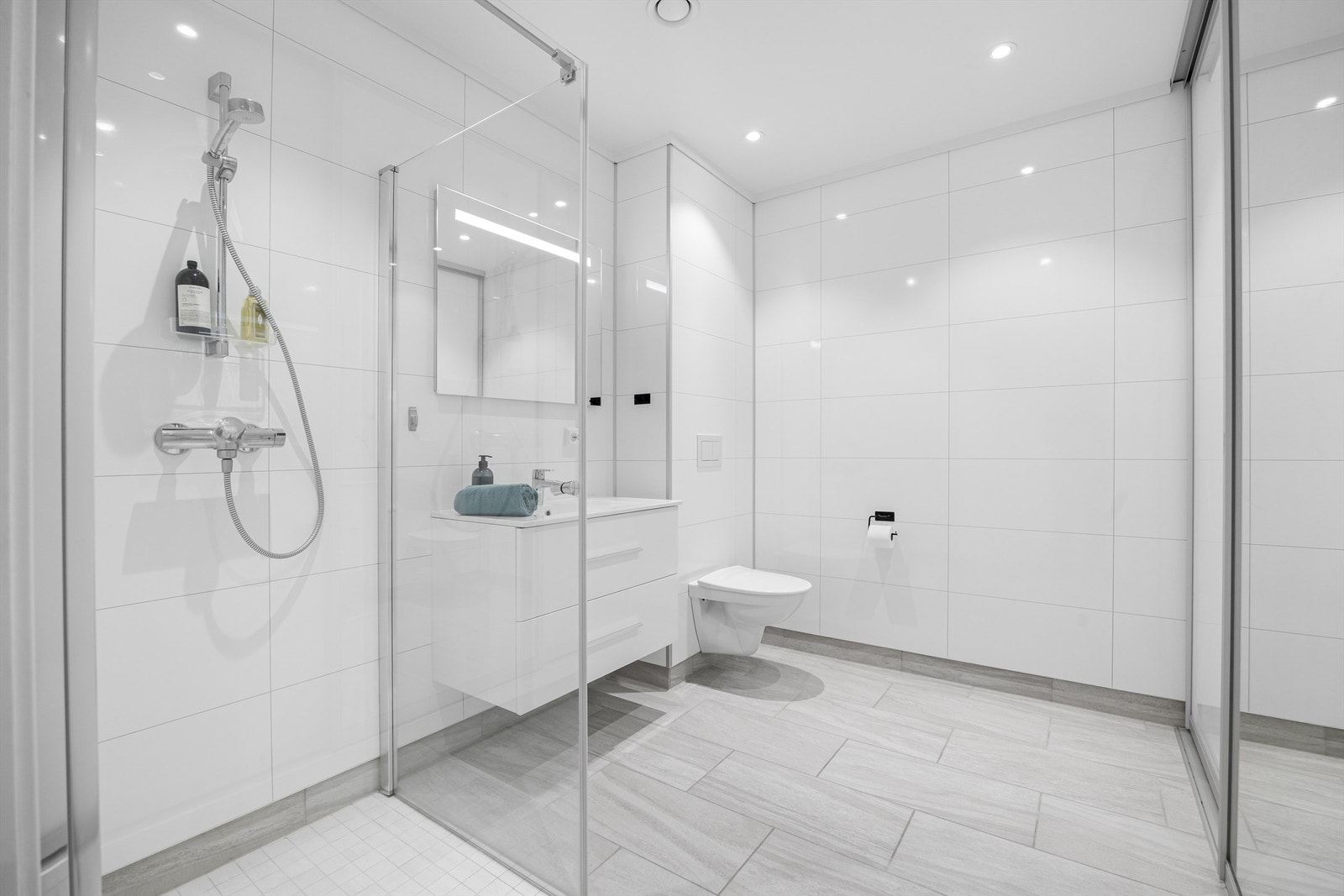 Baderom med vaskerom bak skyvedør med speil. Galleribilde