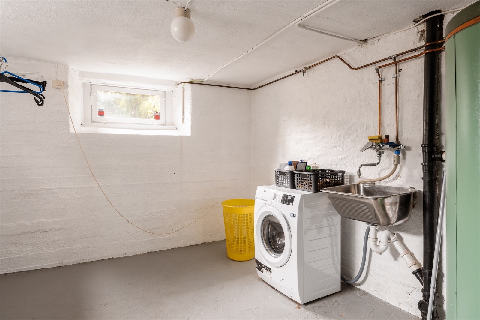 Et separat og romslig vaskerom med opplegg for vaskemaskin og utslagsvask. Galleribilde