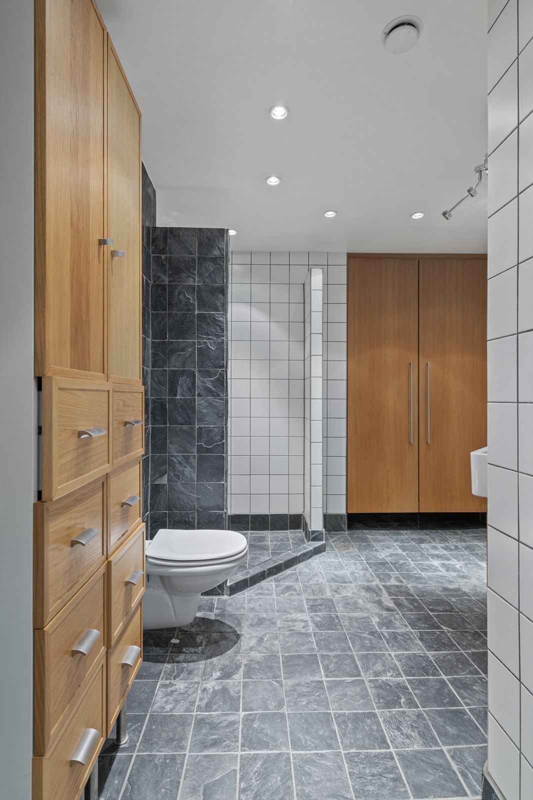 Stort flislagt bad med downlights i himling. Galleribilde