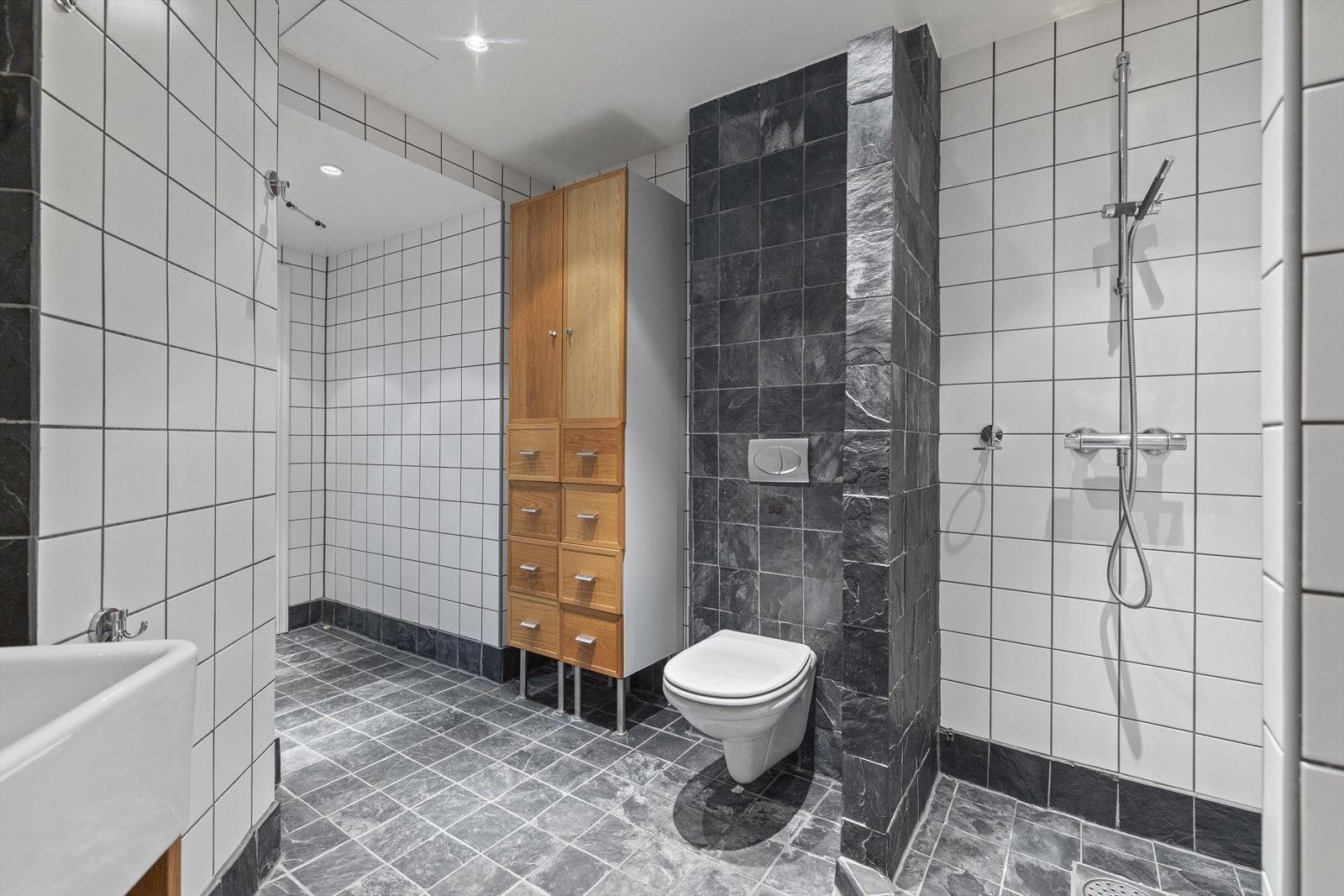 Stort flislagt bad med vegghengt toalett. Galleribilde