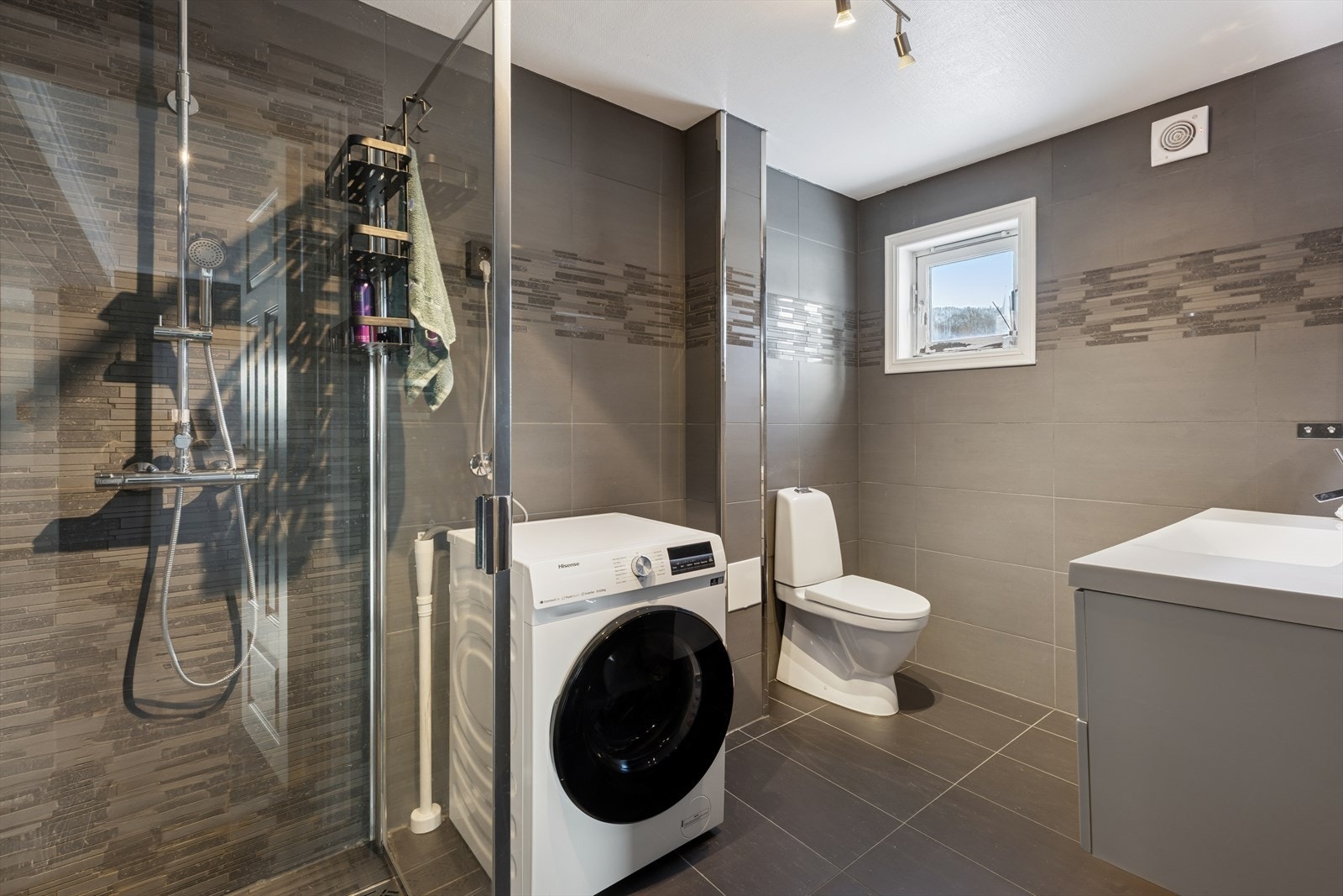 Badet i utleiedelen har flislagte overflater og opplegg for vaskemaskin. Galleribilde