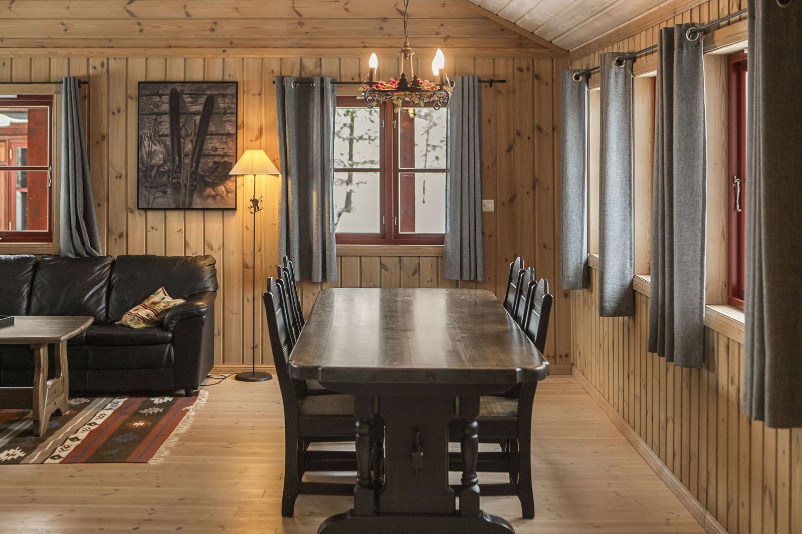 Store vindusflater slipper inn dagslys og rammer inn naturen utenfor. Galleribilde