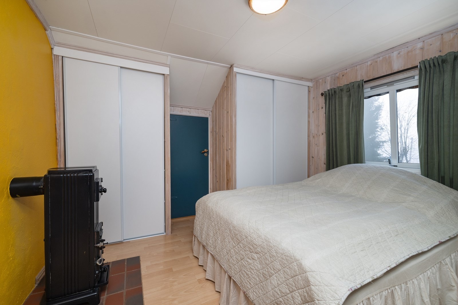 Det ene soverommet på loftet har en egen vedfyrt ovn for ekstra varme og hygge. Galleribilde