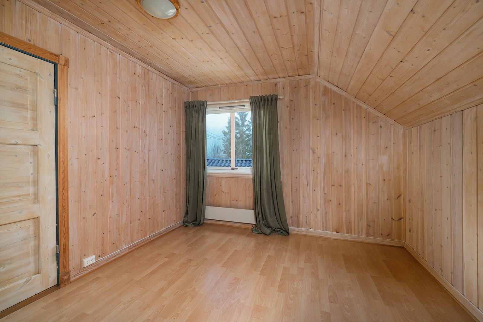 Det andre soverommet har også laminatgulv og vegger kledd med trepanel. Galleribilde