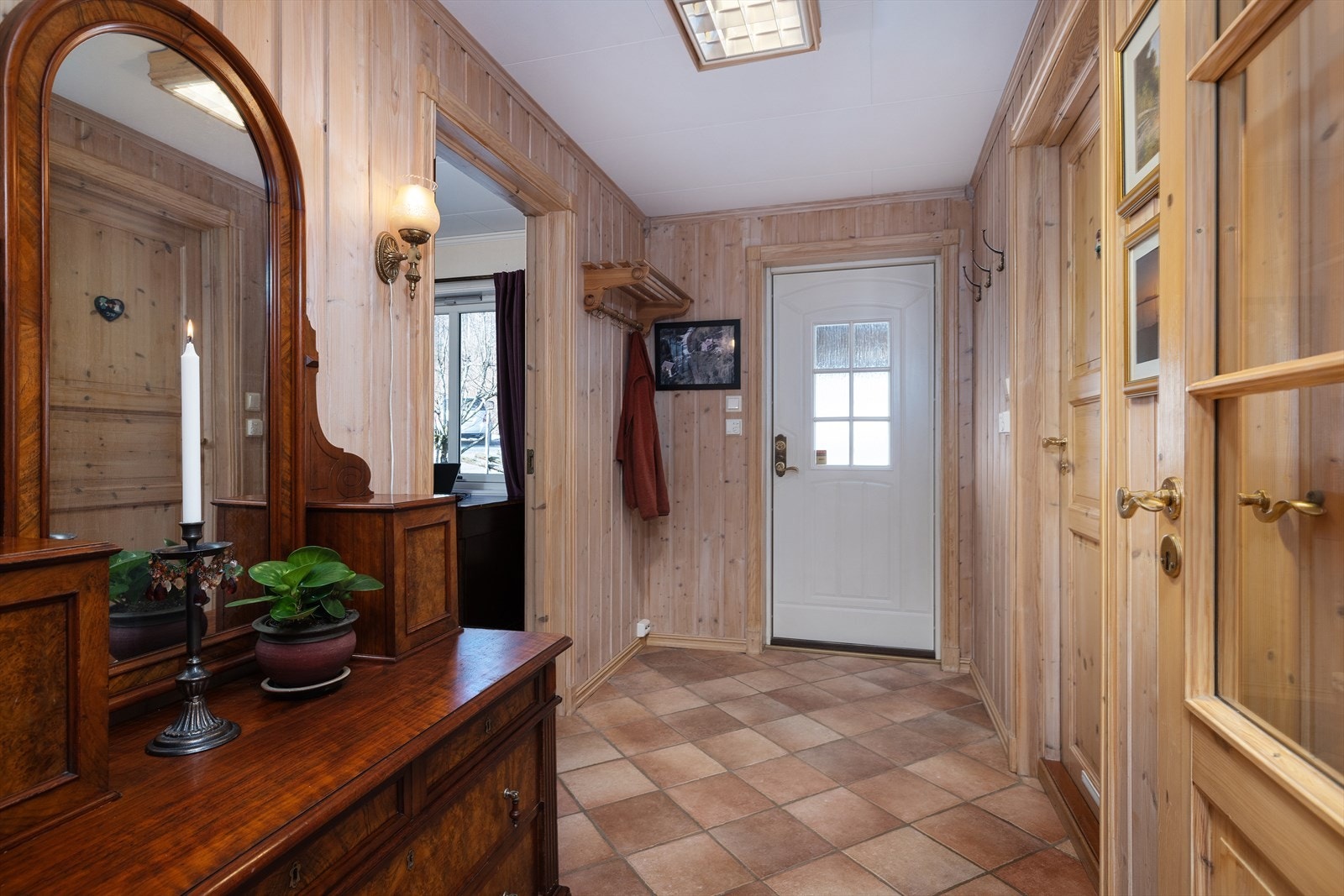 Entréen har flislagt gulv med varmekabler og gir direkte adkomst fra den overbygde carporten. Galleribilde
