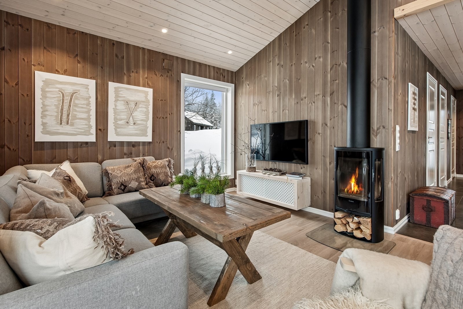 Stuen er et hyggelig samlingspunkt med en moderne Contura vedovn som gir god varme. Galleribilde