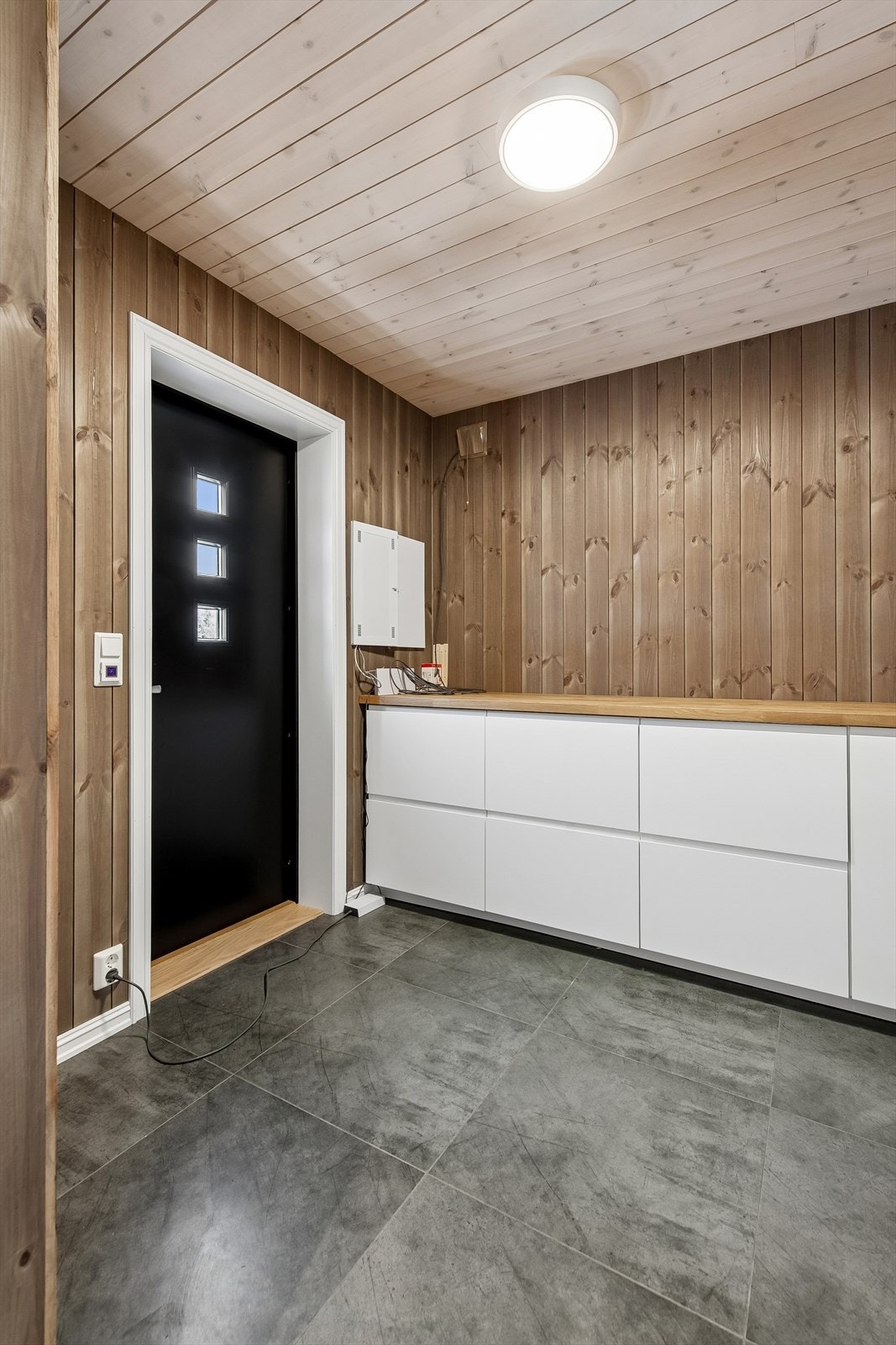 Praktisk vaskerom/bod med egen inngang, flislagt gulv med varmekabler og opplegg for vaskemaskin. Galleribilde