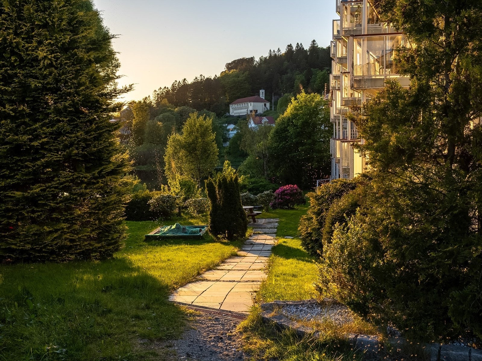 Boligaksjeselskapet har pent opparbeidede fellesarealer med plen og lekeareal. Galleribilde