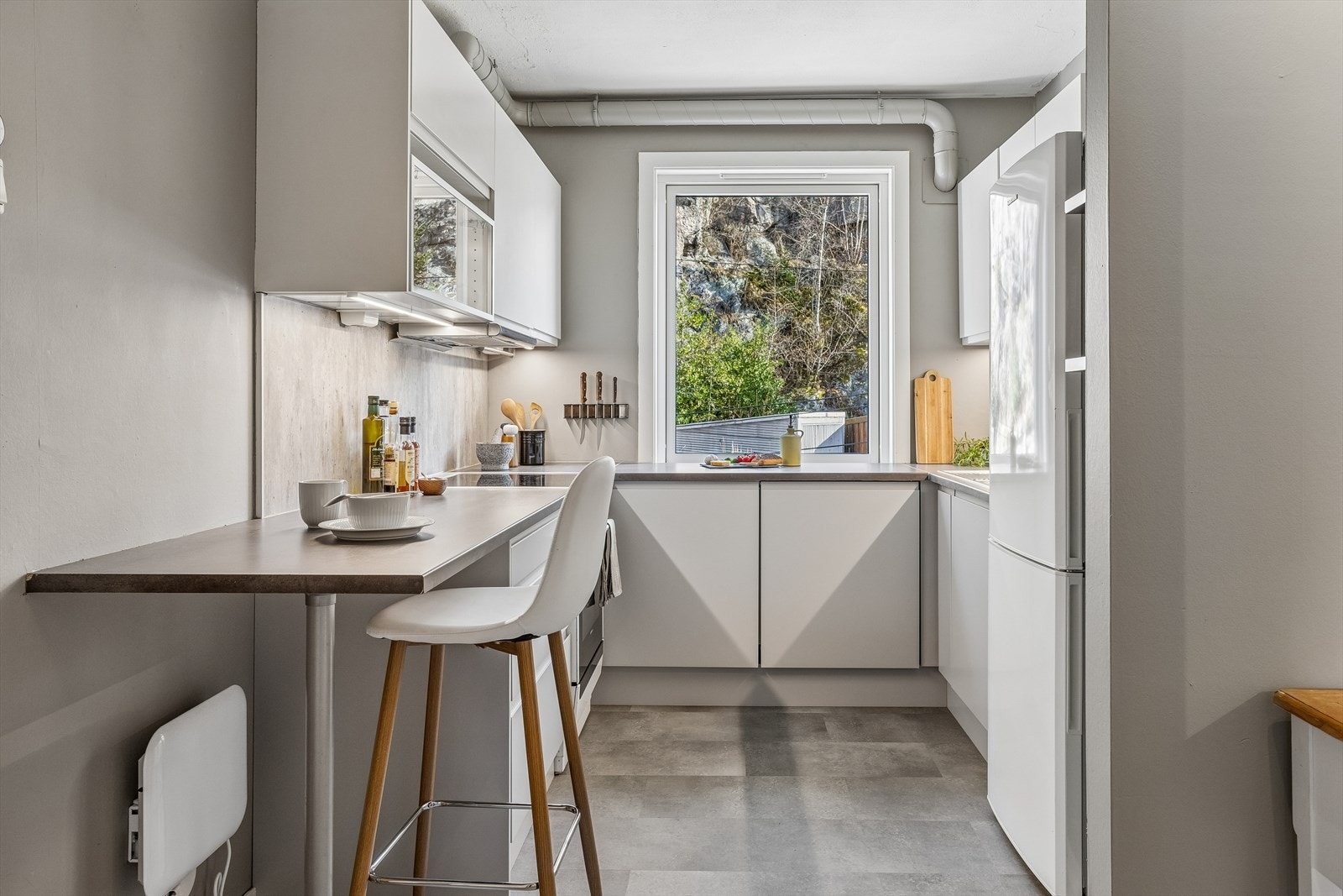 Kjøkkenet har innredning med slette fronter, laminatbenkeplate og ventilator. Galleribilde