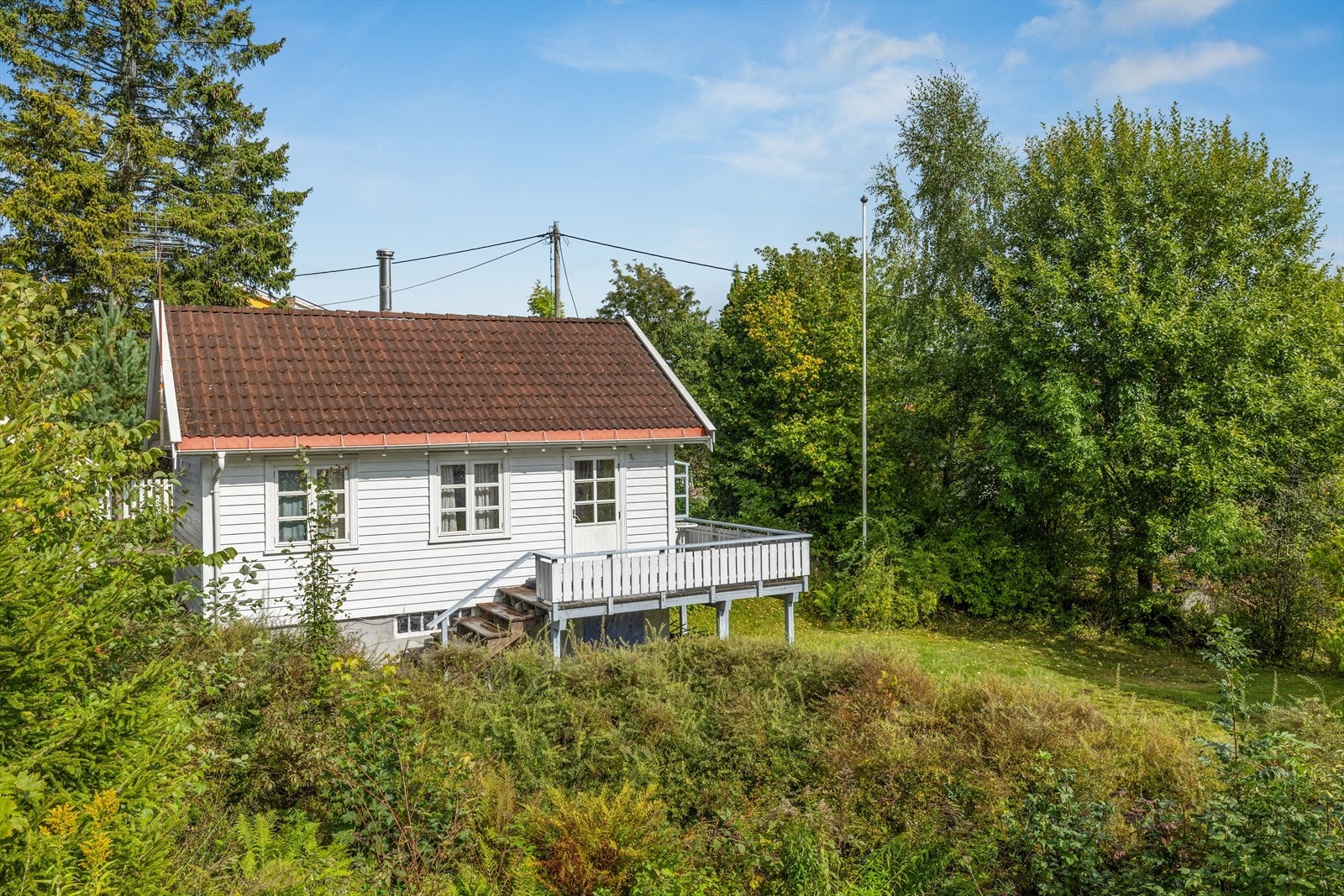 Hytten byr på et fredelig fristed omgitt av grønne kvaliteter, hvor neste eier kan skape sitt eget pusterom. Galleribilde