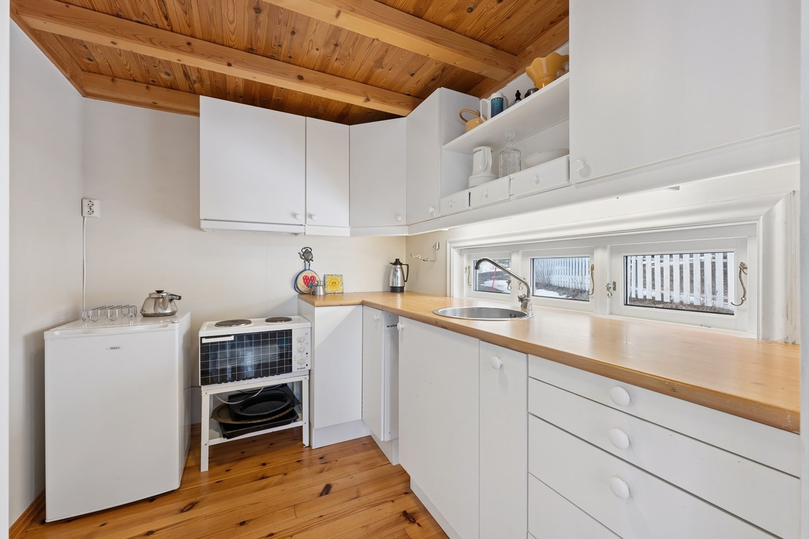 Kjøkkenet ligger i en delvis åpent løsning mot stuen. Her er innredningen enkel, men funksjonell, med glatte fronter, laminert benkeplate og både over- og underskap som gir god utnyttelse av plassen. Kjøkkenet har ventilator med avtrekk ut. Galleribilde