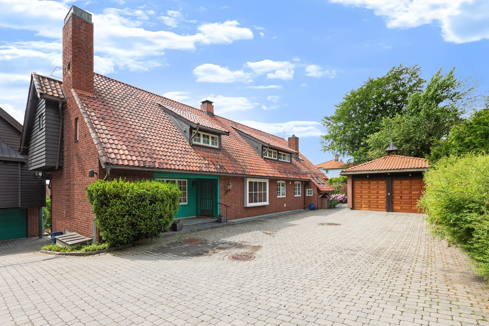 Det er flere garasjer og parkeringsmuligheter på eiendommen. Frittstående dobbelgarasje. Sidebolig med 2 garasjer (en enkel og en dobbel). I tillegg parkeringsmuligheter på gårdsplass med belegningsstener. Galleribilde