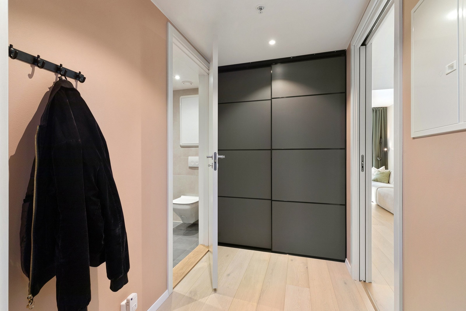 Romslig entré/gang med skyvedørsgarderobe og veggplass for klesoppheng Galleribilde