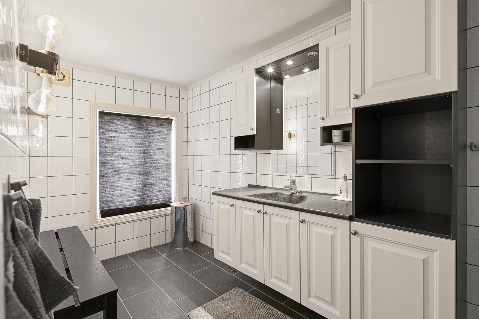 Bad med wc, dusjhjørne, håndvask med speil og tilpassede skap. Galleribilde